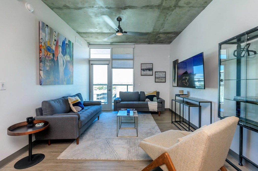 A living room with a grey couch and a wooden chair.