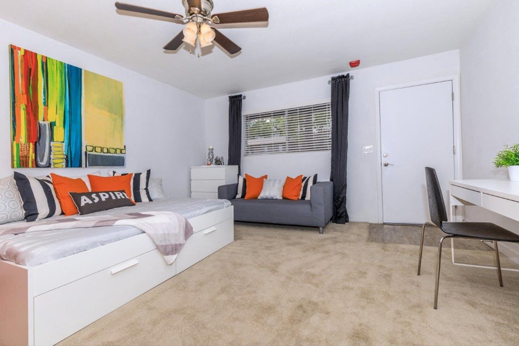 A bedroom with a bed, a chair, and a painting on the wall.