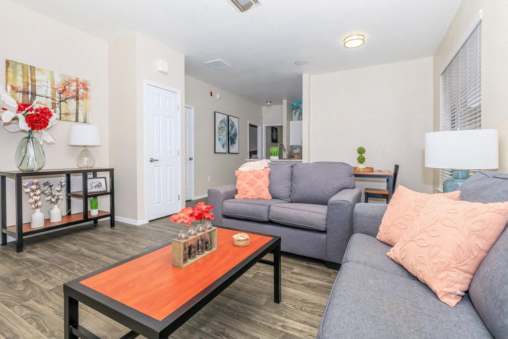 A living room with a grey couch and a wooden coffee table.