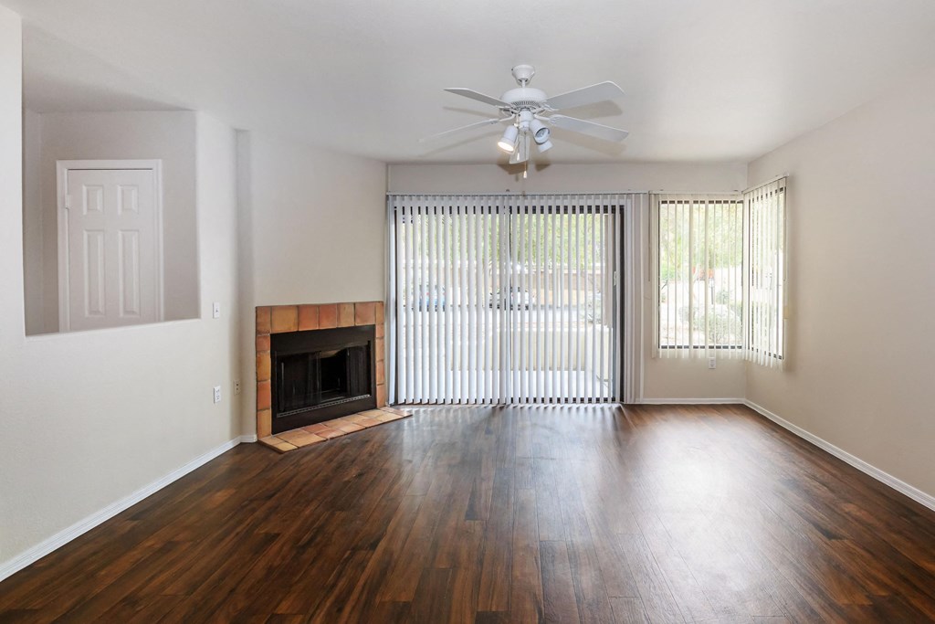 A room with a fireplace and sliding glass doors.