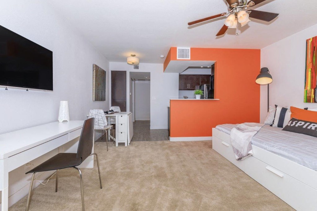 A bedroom with a bed, desk, and chair.