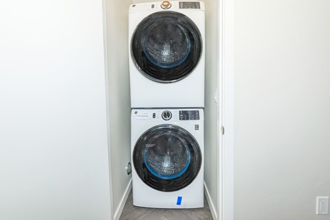 A white front loading washing machine with a blue label on the door.