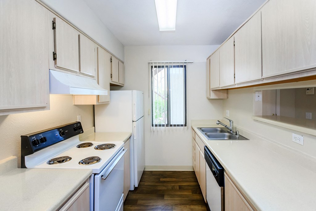 A kitchen with white appliances and wooden cabinets.