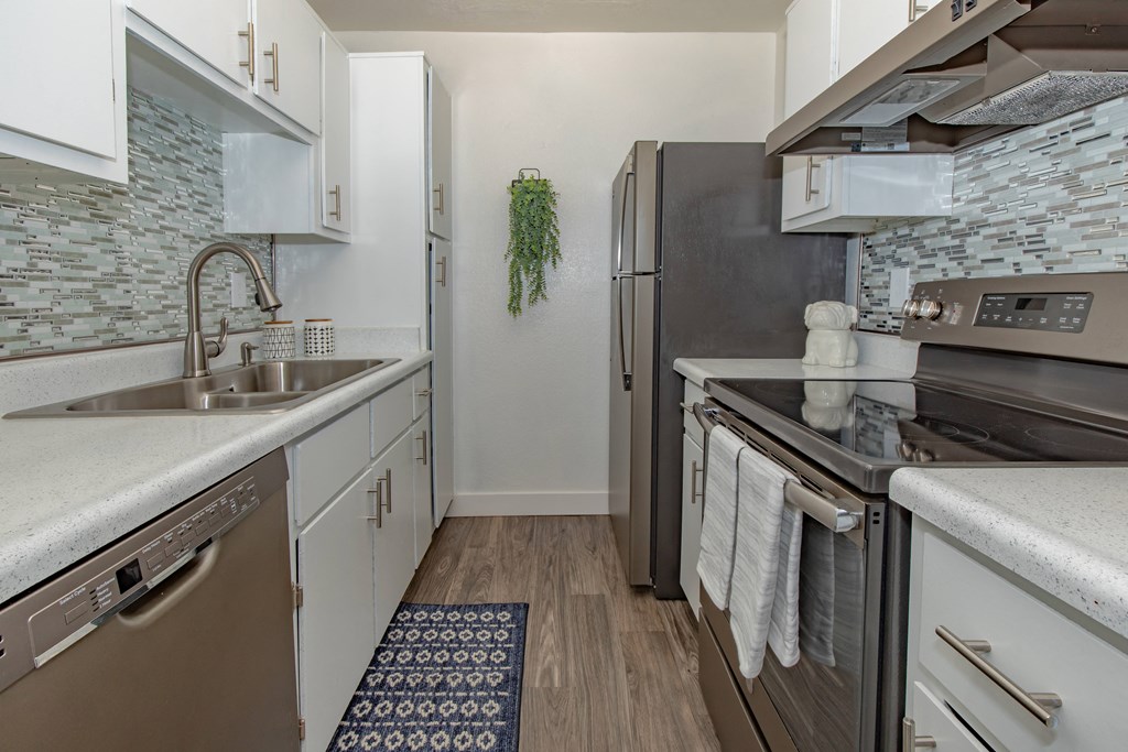 A kitchen with a black refrigerator and a white oven.
