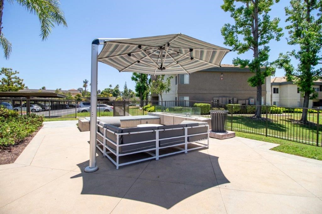a fenced in area with a picnic table and an umbrella