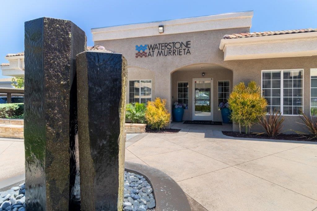 the front entrance with a stone water feature and a building