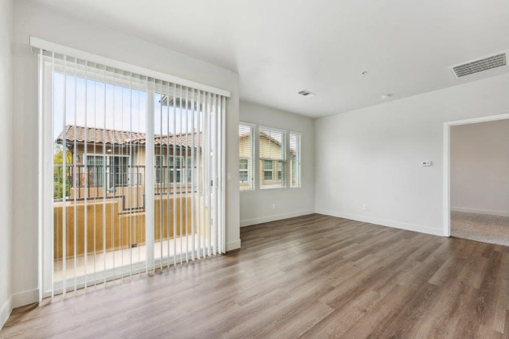 a living room with a large window and a wooden floor