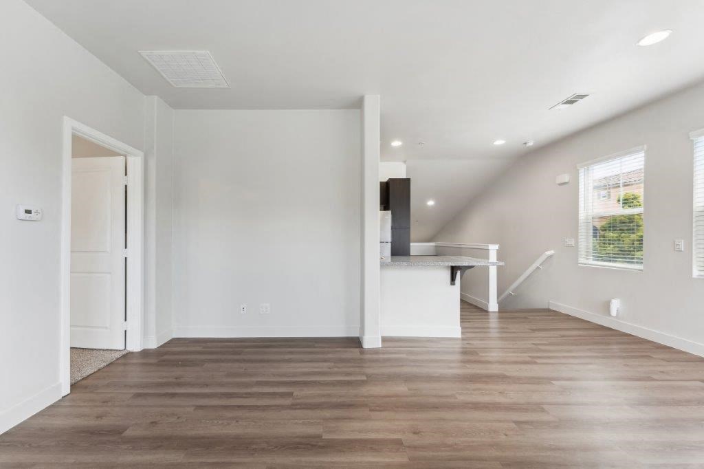 a living room with white walls and a wooden floor