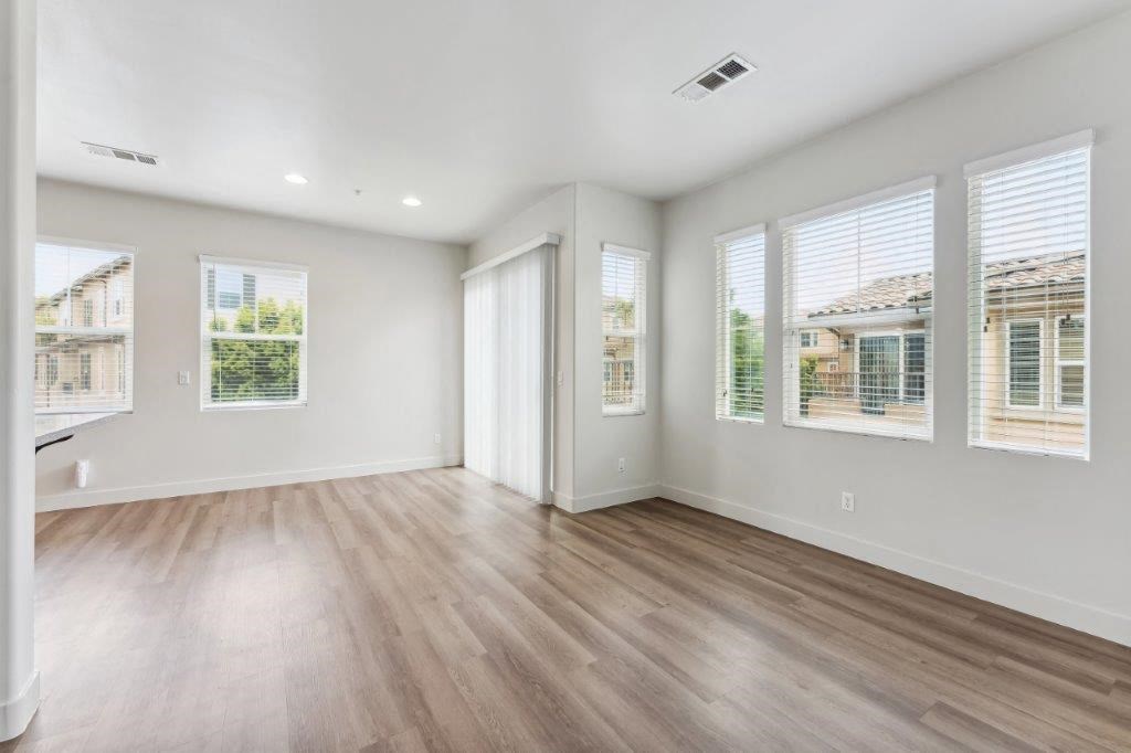 an empty living room with wood floors and windows