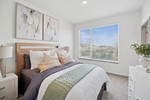 A bedroom with a large bed and two wall art pieces.