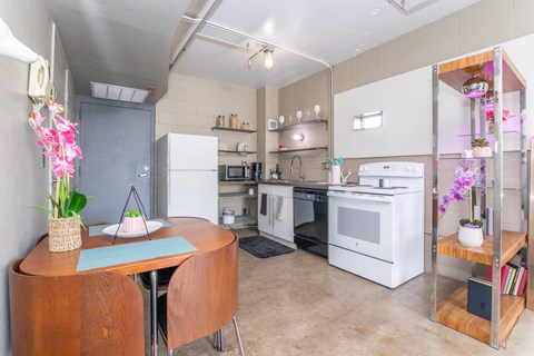 A kitchen with a table and chairs and a refrigerator.