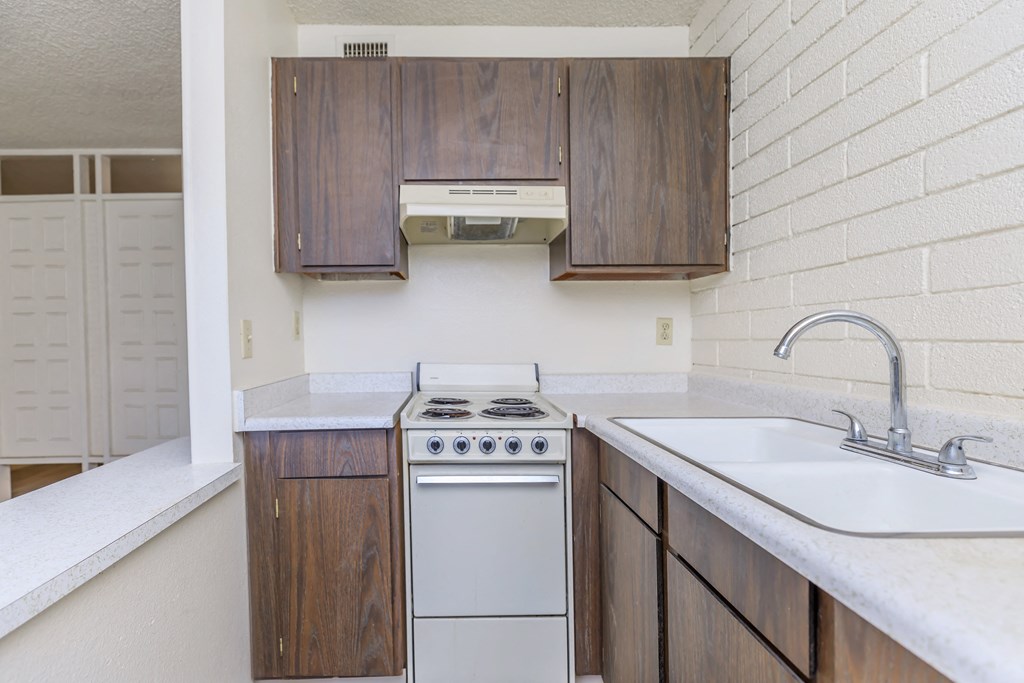 A kitchen with a white counter top and a white sink.