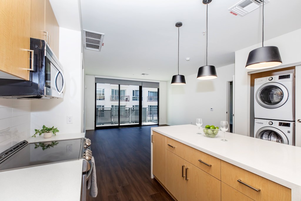 A kitchen with a stainless steel sink and white cabinets.