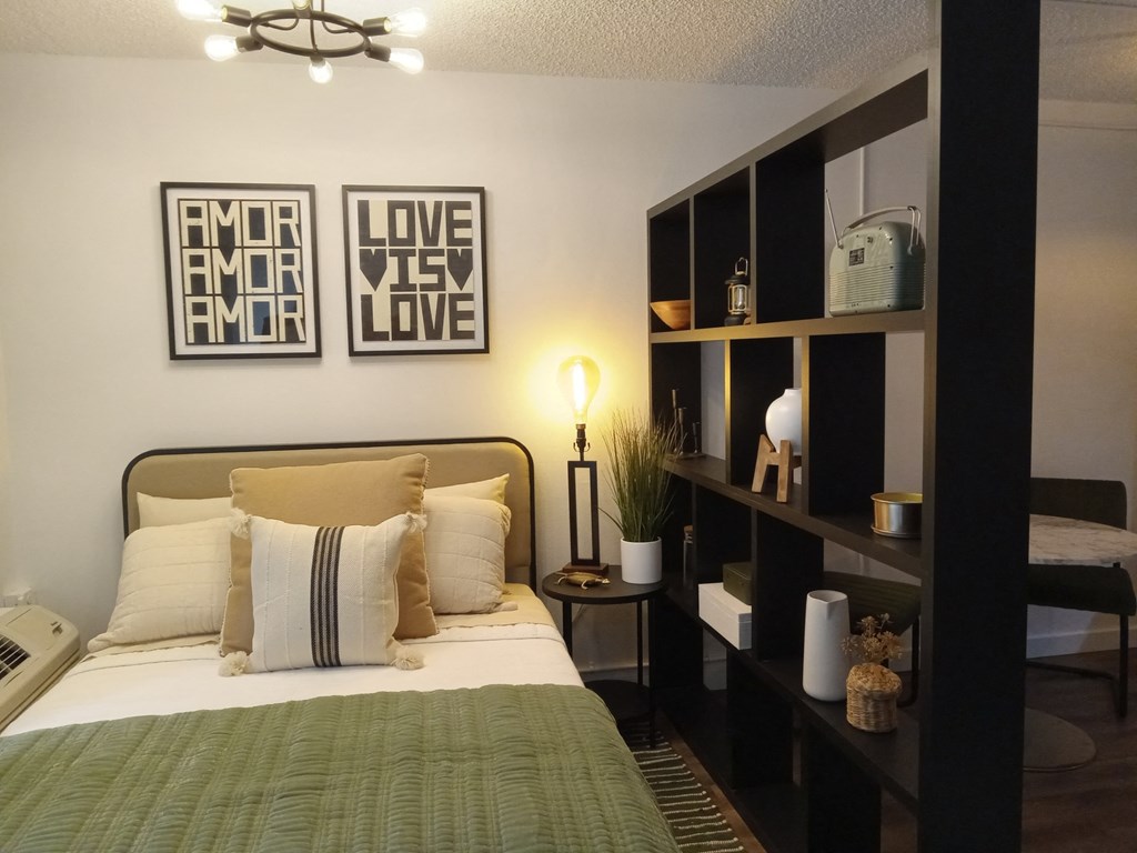 a bedroom with a bed and pictures on the wall