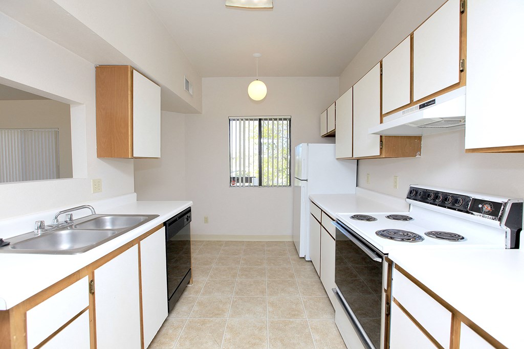 A kitchen with white appliances and wooden cabinets.