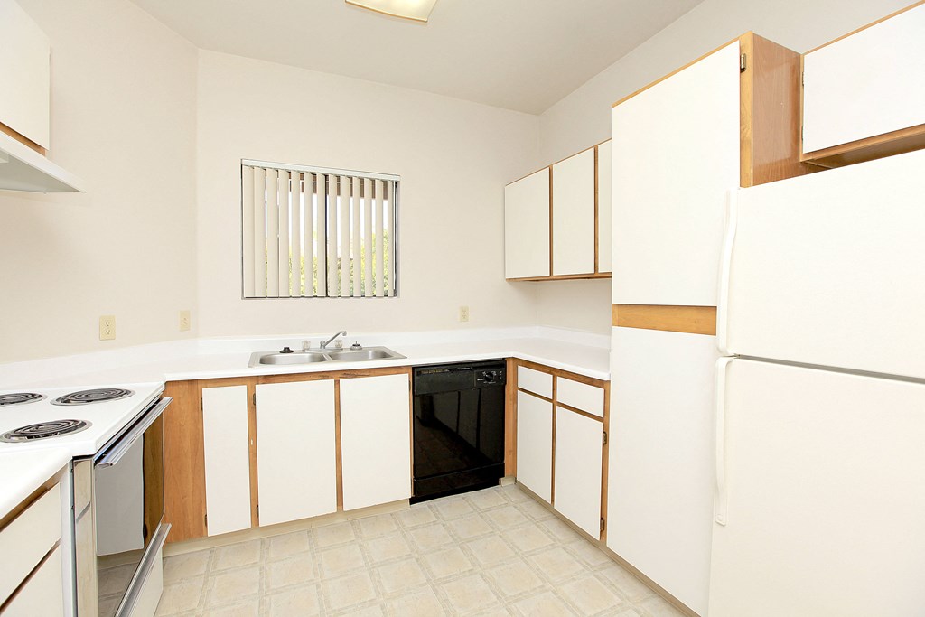 A kitchen with white cabinets and a black dishwasher.