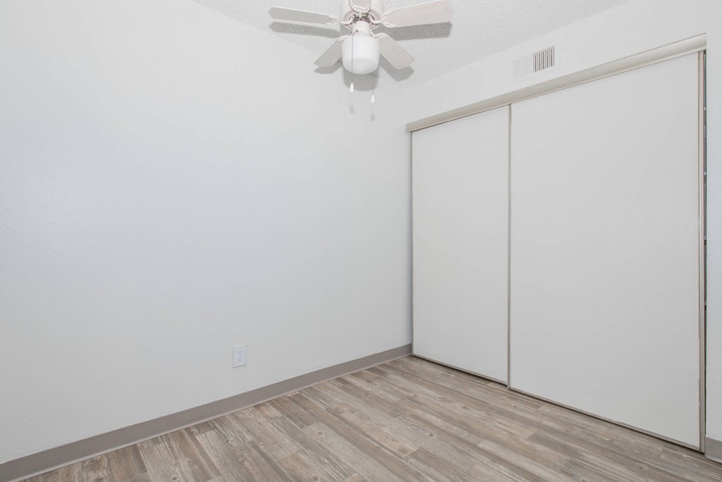 A room with a ceiling fan and a sliding door.