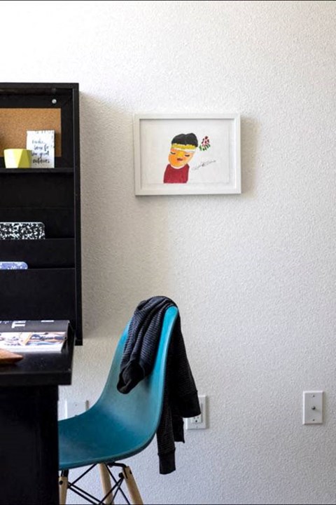 a blue chair in a room with a painting on the wall