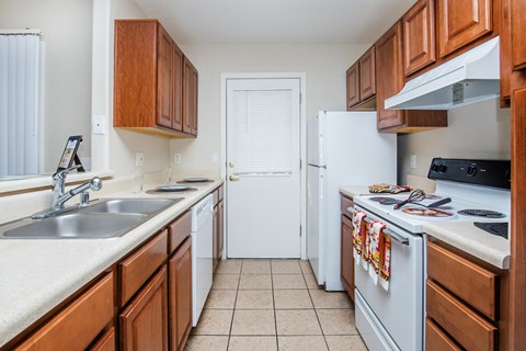 A kitchen with white appliances and wooden cabinets.