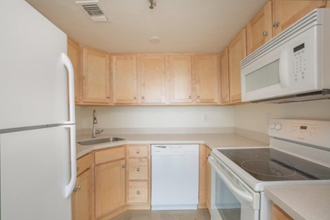 A kitchen with wooden cabinets and white appliances.