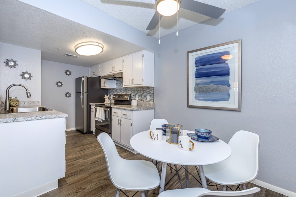 A kitchen with a table and chairs in the middle of the room.