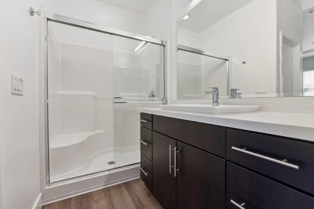 a bathroom with a shower and a sink and a mirror