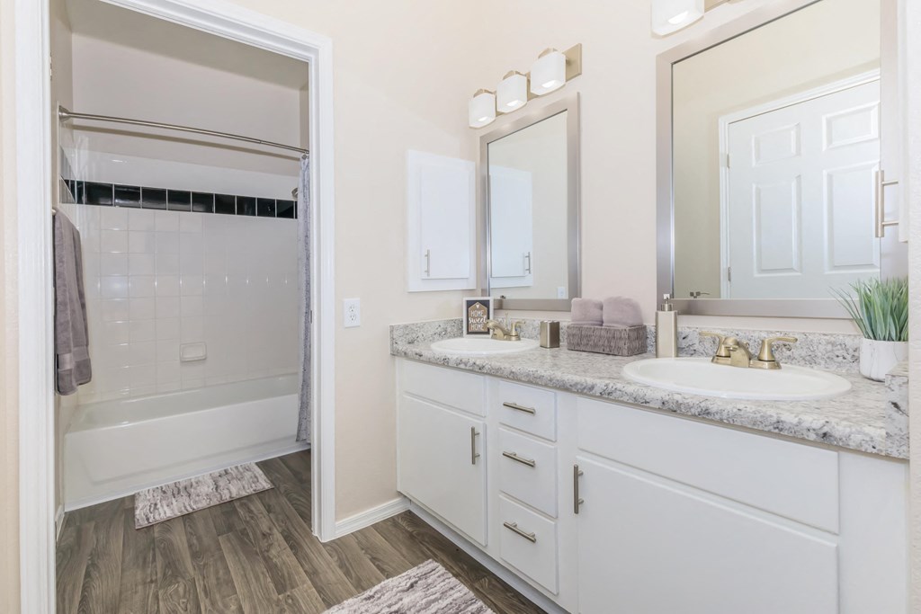 A bathroom with a white tub and sink.