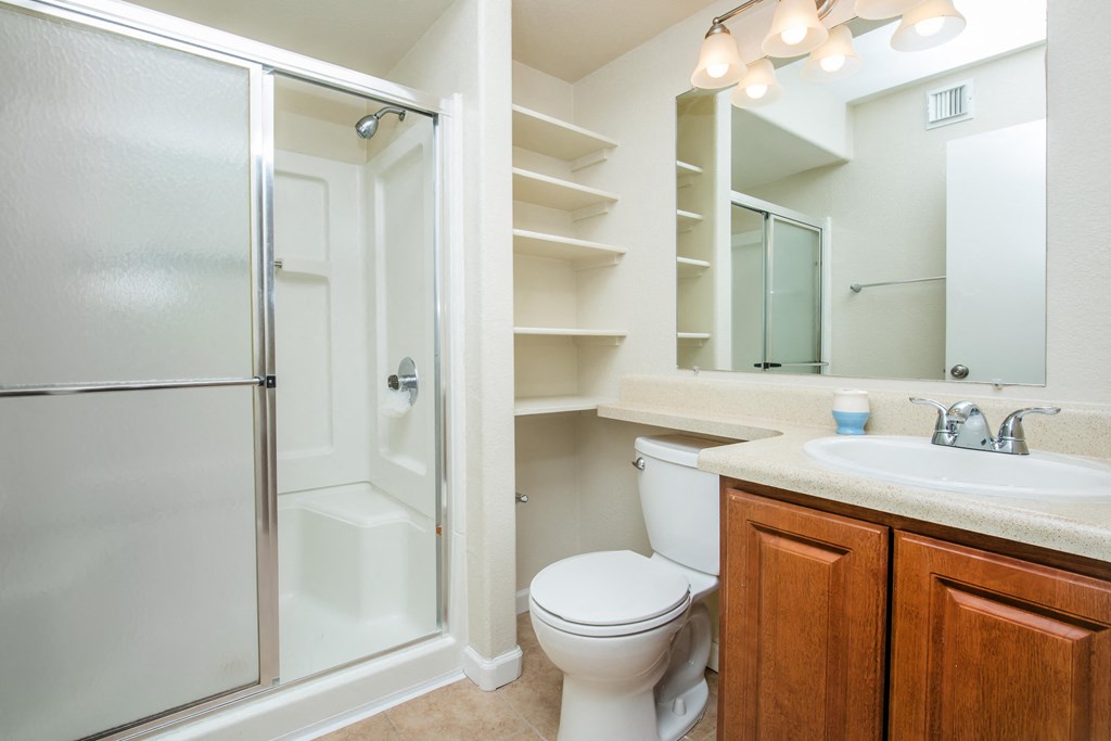 A white bathroom with a toilet, sink, and shower.