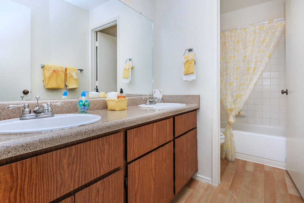A bathroom with a white sink and a wooden vanity.