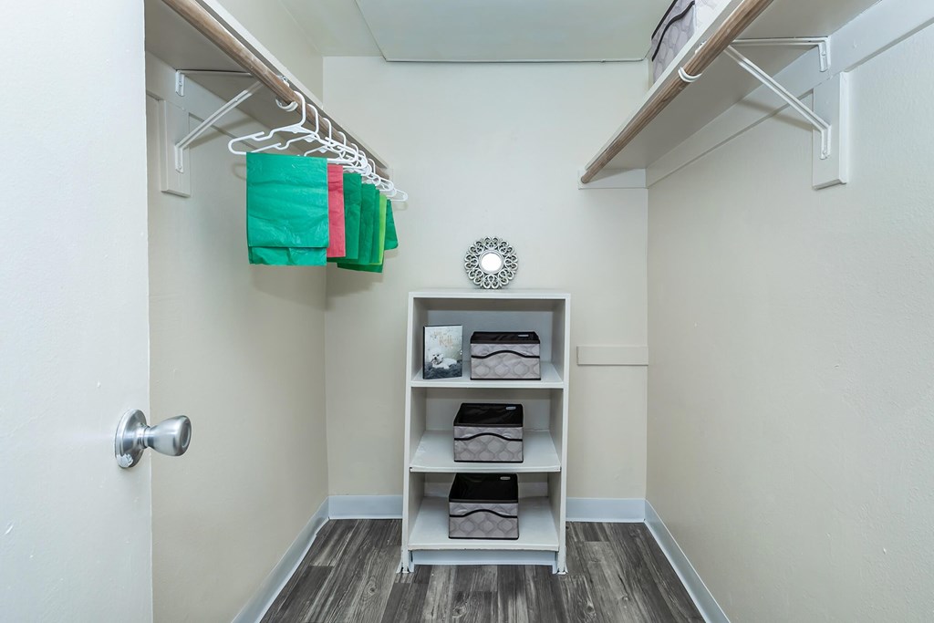 A small, clean, and organized closet with a shelf and a door.