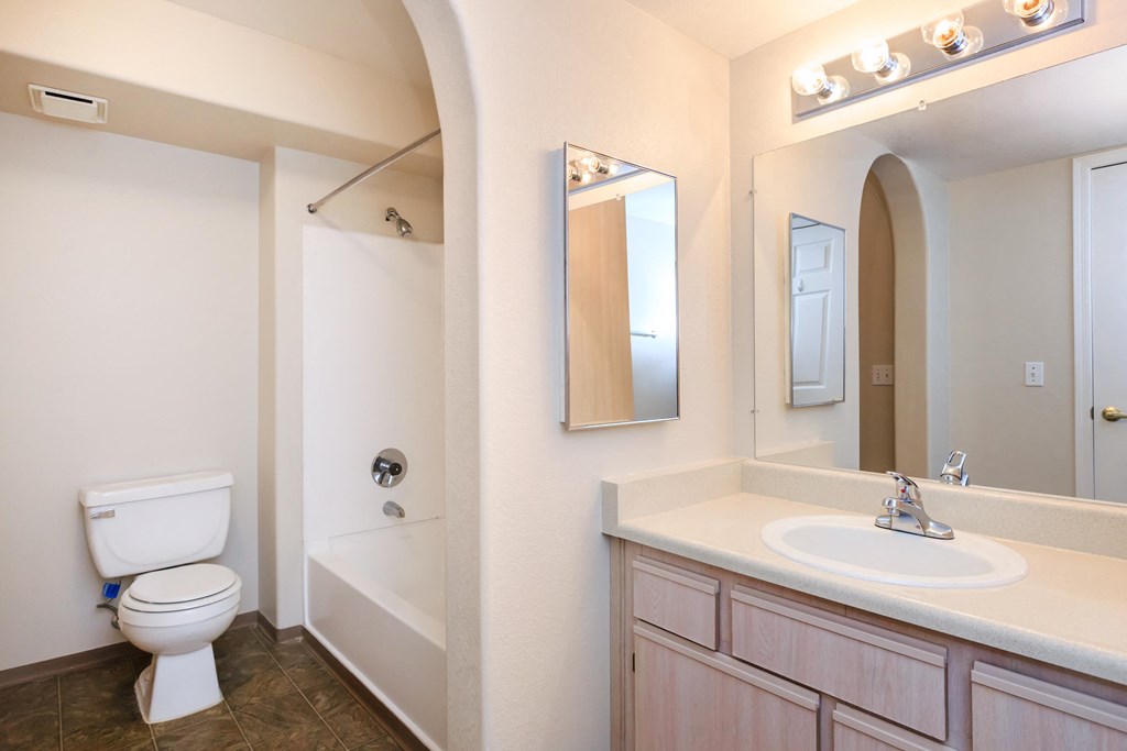 A white toilet is next to a bathtub in a bathroom.