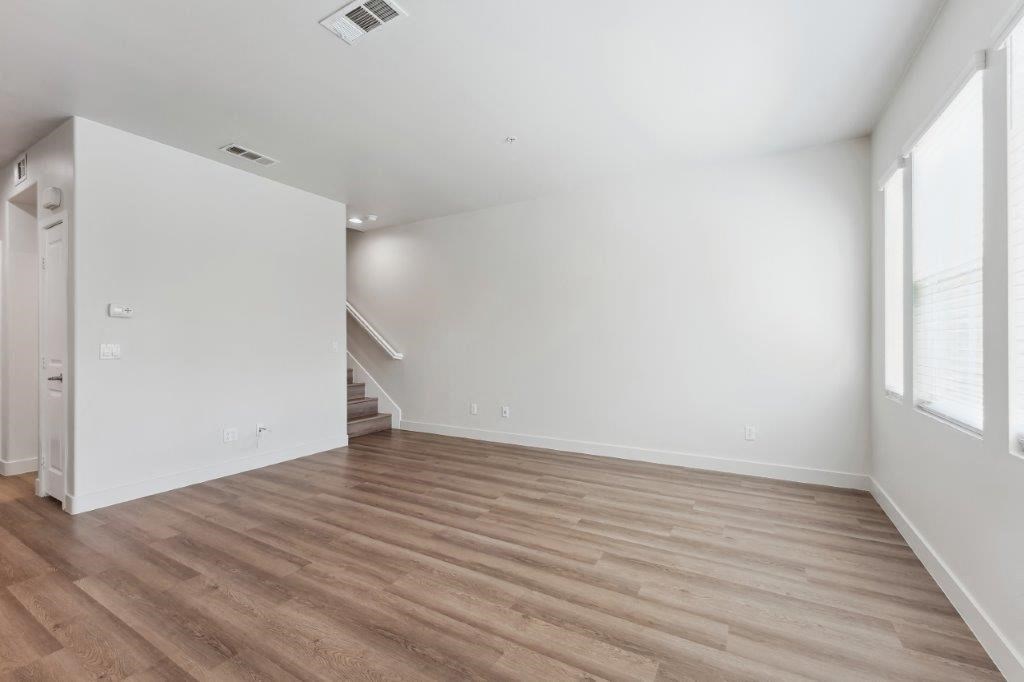 an empty living room with white walls and wood floors