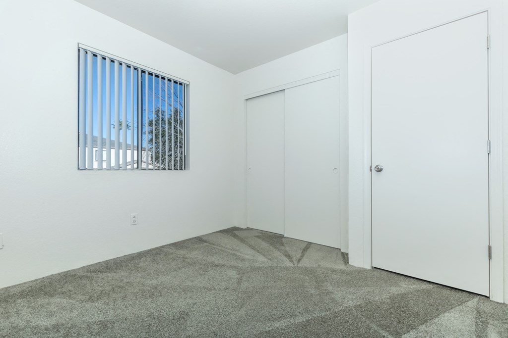 A room with a window and two doors.