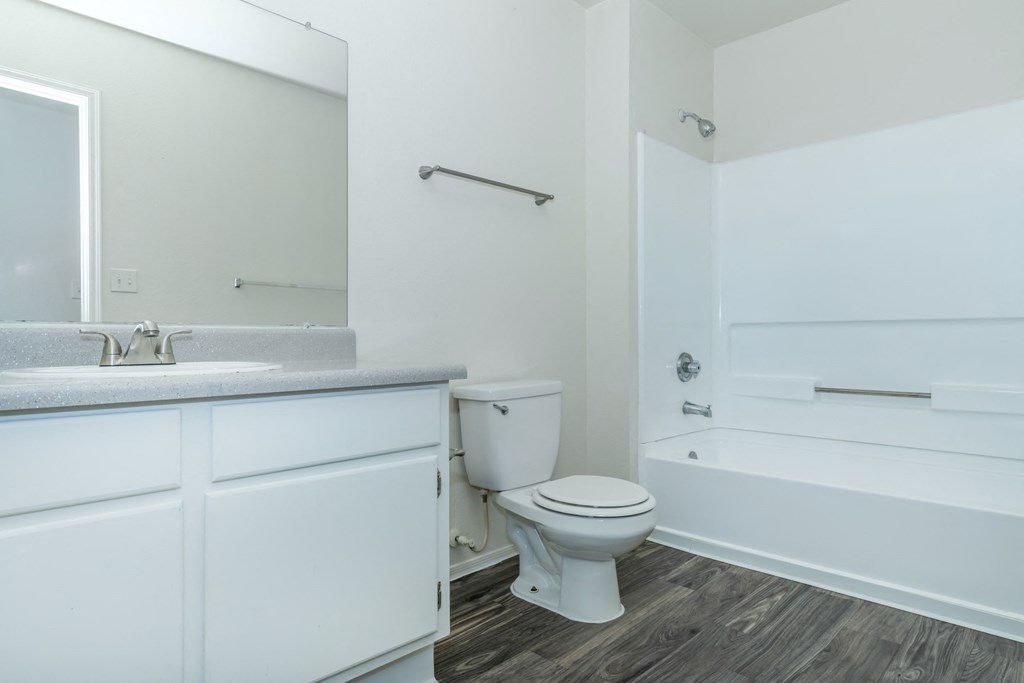 A white bathroom with a toilet, sink, and bathtub.