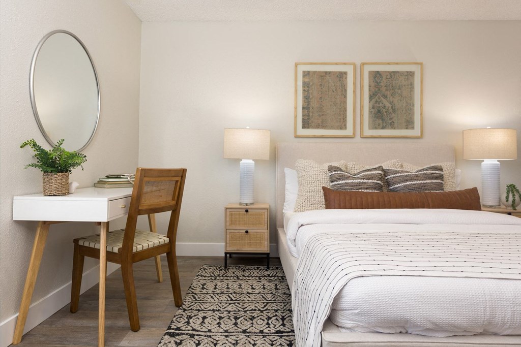 a bedroom with a bed and a desk with a mirror