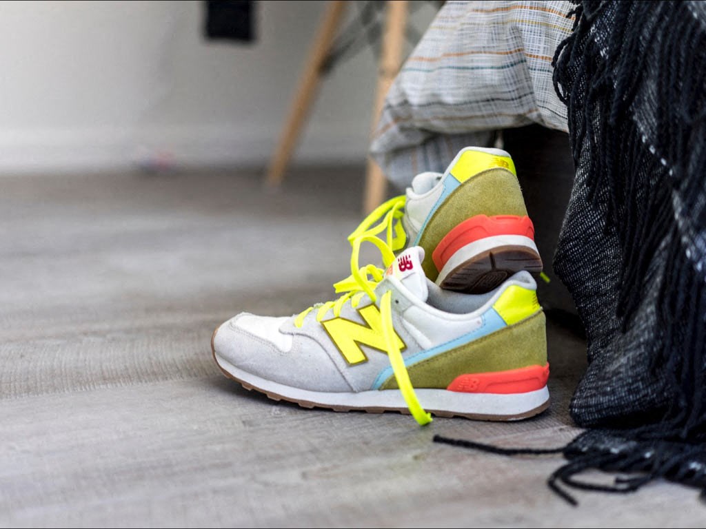 a close up of a person laying on the floor wearing a pair of sneakers