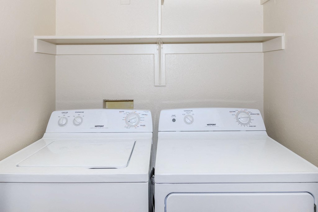 Two white front loading washing machines in a laundry room.