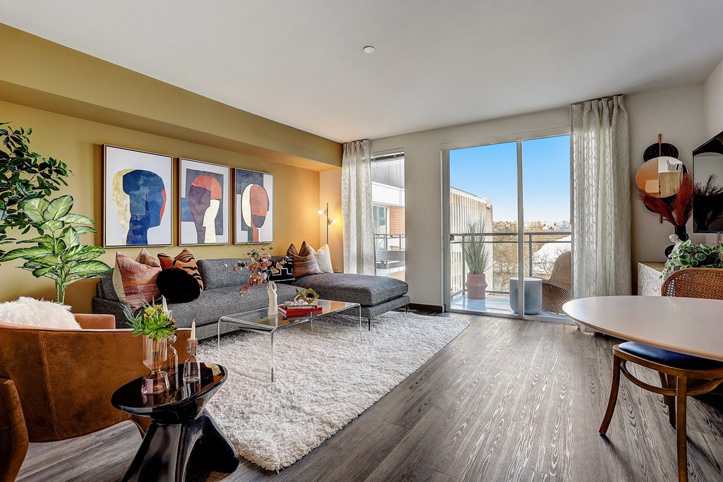 a living room with a couch and a table  and a balcony