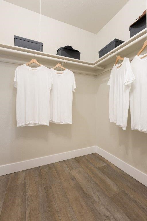 four white shirts hanging on a rack in a room