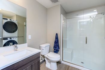 A modern bathroom with a toilet, sink, and shower.