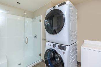 A white front load washing machine in a laundry room.