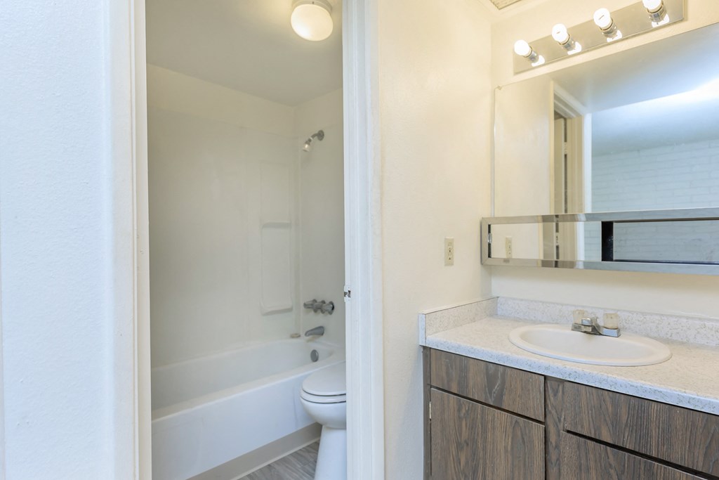A white bathroom with a white tub and sink.