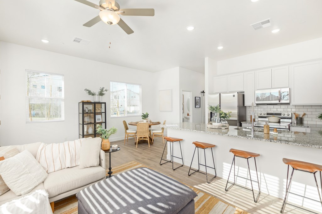 A modern living room with a bar area and kitchen in the background.