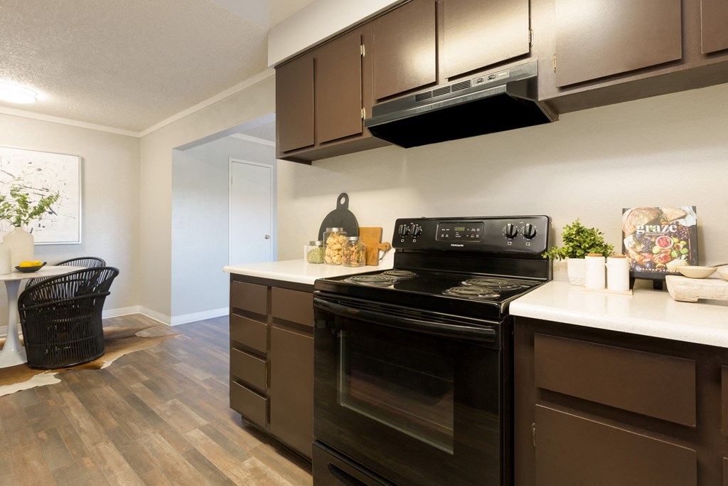 a kitchen with dark cabinets and white countertops