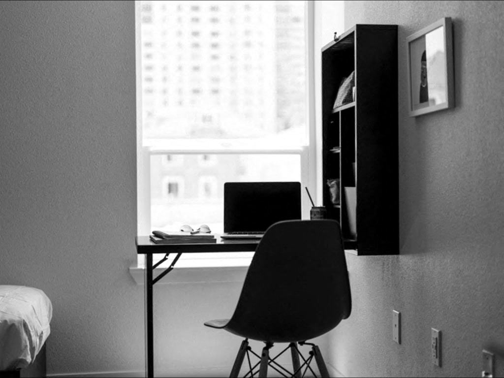 a black and white photo of a desk with a laptop