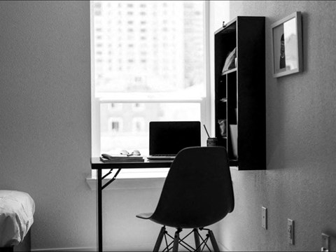 a black and white photo of a desk with a laptop