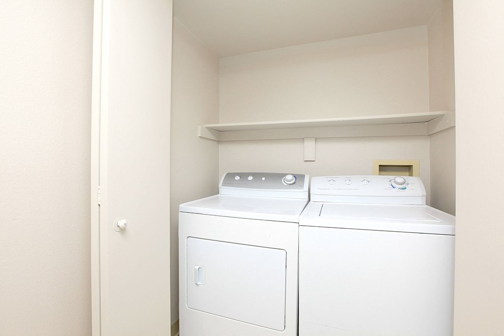 A white washing machine and dryer in a small laundry room.