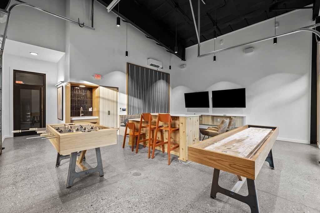 a large room with tables and chairs and a game system in the center of it