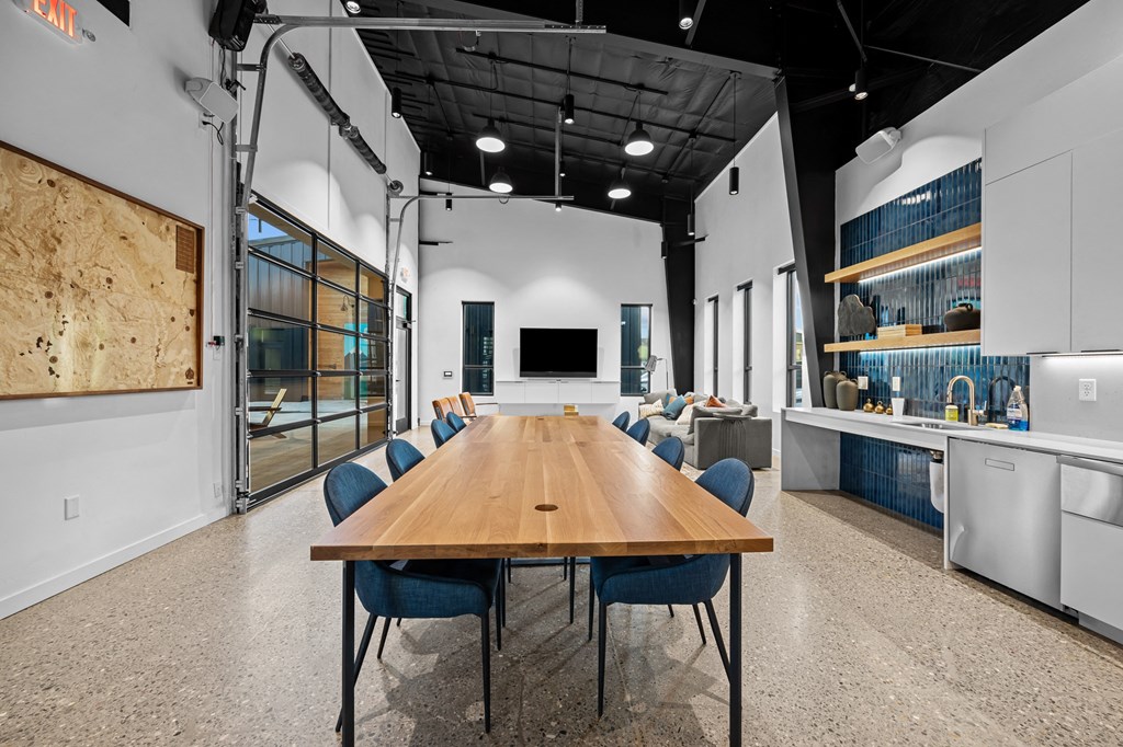a large conference room with a long wooden table and blue chairs