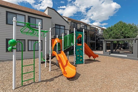 Playground area with colorful slides and climbing features at Overlook at Pantano Apartments, Arizona, 85710